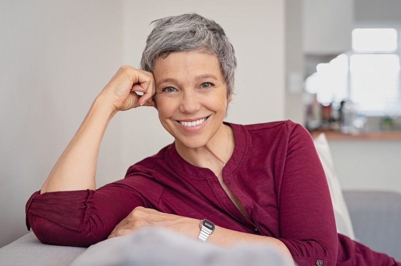 Portrait of smiling senior woman relaxing on a couch at home.